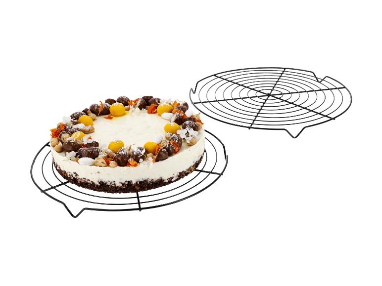 Cheesecake met chocolade, noten en fruitdecoraties op een koelrek.