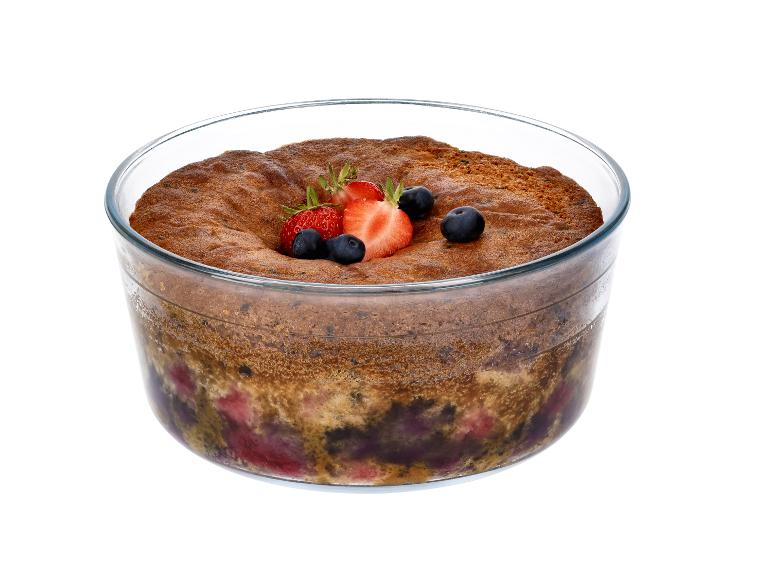 Fruitcrumble met aardbeien en bosbessen in een glazen kom.