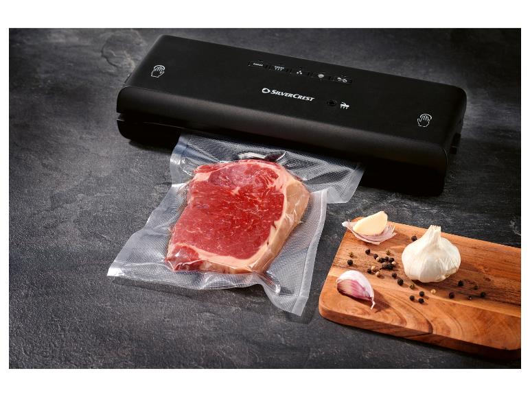 SilverCrest vacuümsealer met vacuüm verpakte biefstuk, knoflook en peperkorrels op een houten plank.