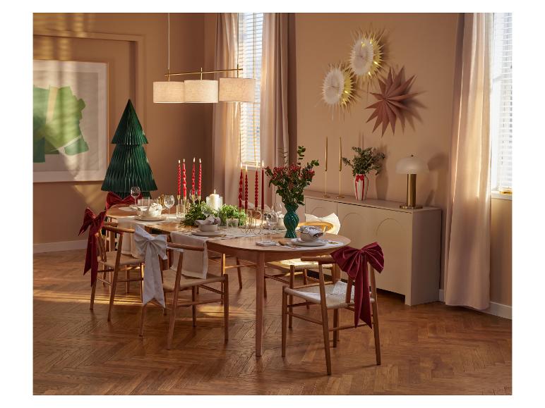 Elegant gedekte kersttafel met houten stoelen en feestelijke decoraties.