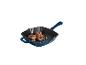 Blauwe gietijzeren grillpan met vleesfilets en groenten