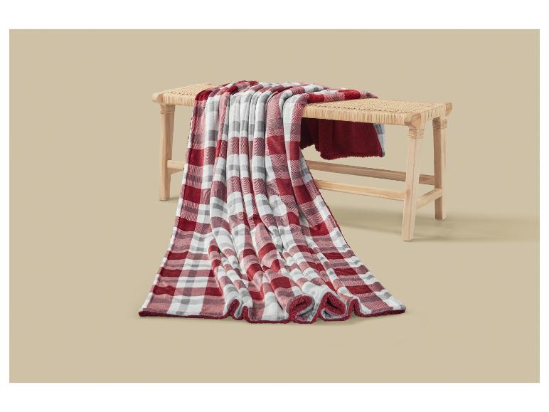 Rood-wit geruite deken gedrapeerd over een houten bank.