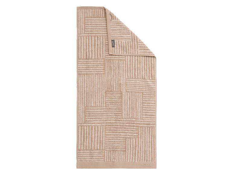 Beige badhanddoek met een geometrisch gestreept patroon en een effen rand.