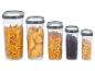 Vijf transparante containers met pasta, maïs, koffie en haver.