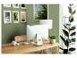 Thuiswerkplek met houten bureau, computer, witte lamp en potplanten.