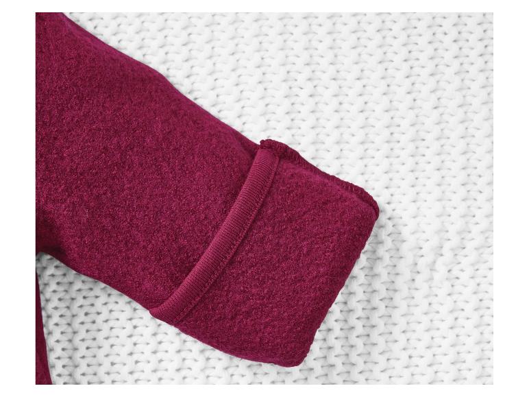 Donkerrode trui op witte gebreide stof.