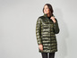 Een vrouw draagt een lange, groene, gewatteerde jas.