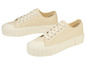 Beige canvas sneakers met dikke witte zool.