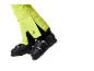 Benen in neongele skibroek en zwarte skischoenen.