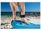 SUP-board en veiligheidsleash op een zonnig strand.