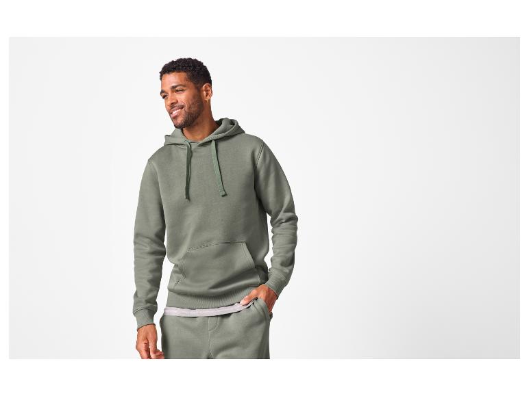 Man in een olijfgroene hoodie en joggingbroek