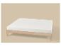 Licht houten bedframe met wit matras op een beige achtergrond.
