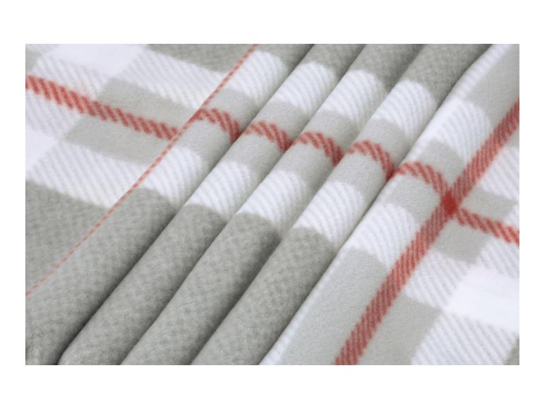 Zachte fleece deken met een wit, grijs en rood ruitpatroon.