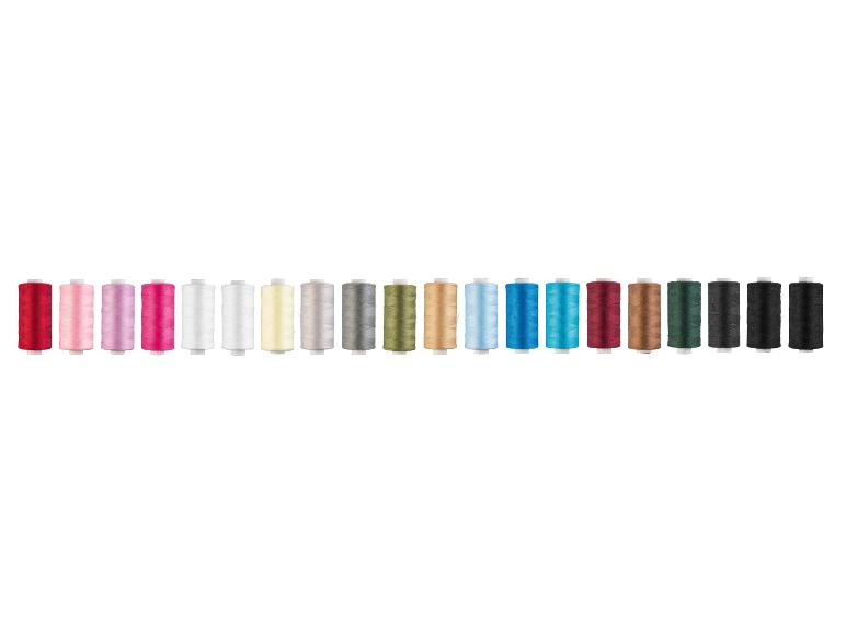 Een rij kleurrijke garenklosjes in verschillende tinten rood, roze, wit, geel, grijs, groen, blauw, bruin en zwart.