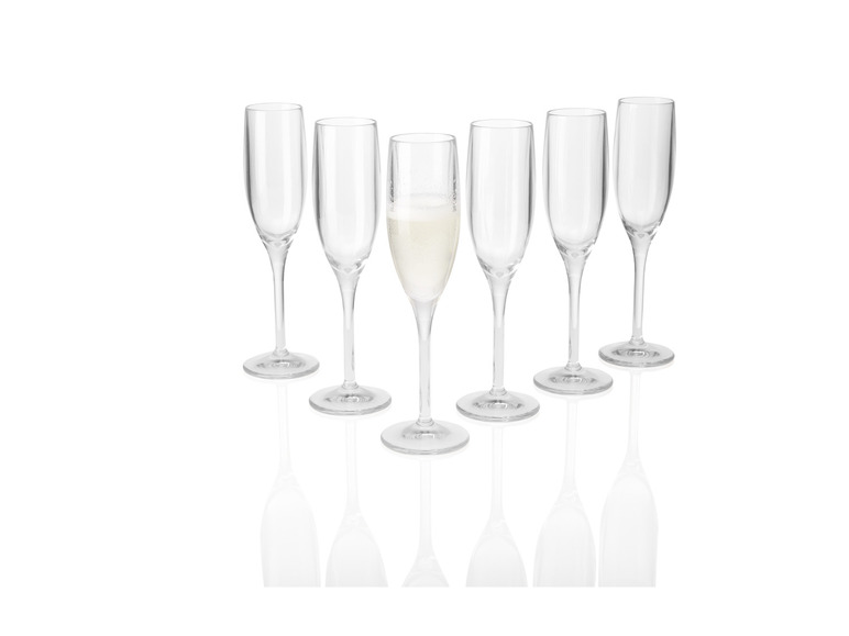 Een glas champagne met vijf lege glazen.