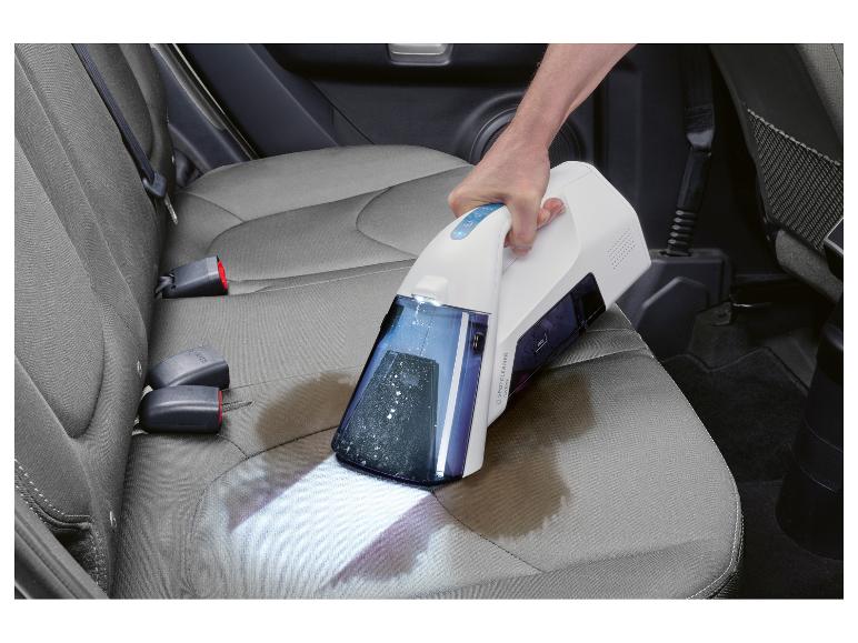 Draadloze vlekkenreiniger gebruikt om een autostoel met een vlek schoon te maken.