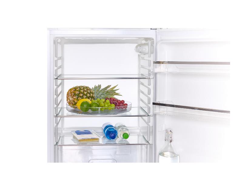 Open koelkast met fruit, waterflessen en kaas.