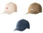 Drie baseballpetten: beige met een rood hart, bruin met het woord 'WORK' en blauw.
