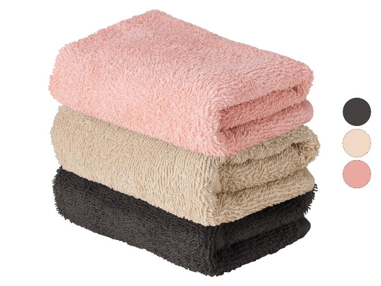 Stapel katoenen handdoeken in roze, beige en donkergrijs.