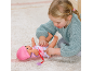 Een kind speelt met een babypop op een tapijt en kleedt deze in een roze outfit.
