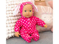 Een babypop met roze stippen pyjama met konijnenoortjes.