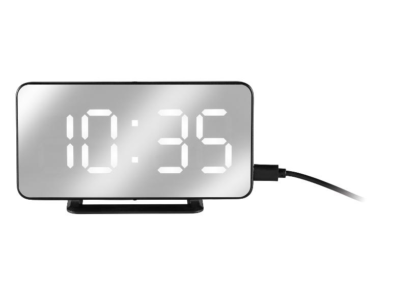 Digitale spiegelklok toont 10:35, met een zwarte stroomkabel.