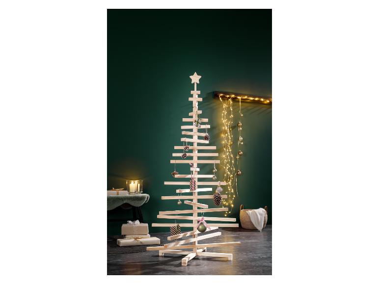 Een moderne houten kerstboom versierd met ornamenten en lichtjes in een feestelijke kamer.