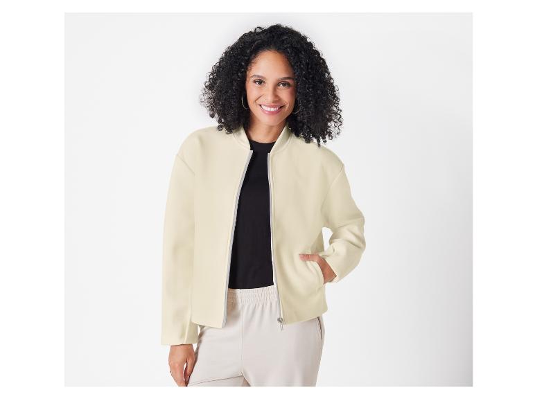 Een vrouw draagt een crèmekleurige bomberjack.