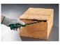 Een hand met een Parkside schroevendraaier opent een houten kist.