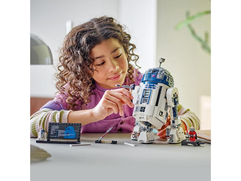 Een kind bouwt een LEGO Star Wars R2-D2 droid.