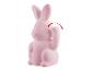 Een roze konijnenbeeldje met een opstaand pootje.