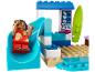 Speelgoedbouwset met een glijbaan, een speelfiguur en een surfplank op het strand.