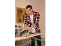 Man gebruikt een multitool om hout te schrapen, draagt veiligheidsbril en oordopjes.