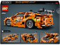 Oranje speelgoedauto met groene vlammen en een achterspoiler, met motor- en deurdetails.