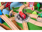 Houten treinset met rode brandweerwagen, rails en figuren op een speelkleed.