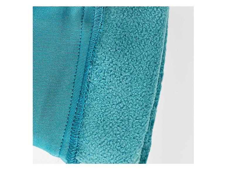Naad tussen turquoise gebreid materiaal en fleece.