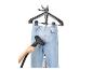 Kledingstomer strijkt jeans op een hanger.