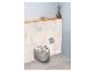 Toilet met bloemenpatroon, wandplank met vaas en toiletrolhouder.
