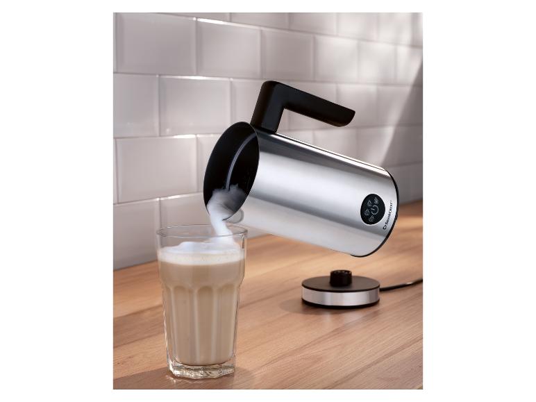 Zilveren Silvercrest melkopschuimer op houten aanrecht, schenkt schuim in een glas.