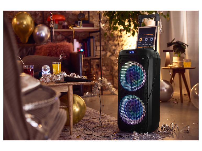 Karaoke luidspreker met microfoon en tablet, omringd door feestversiering en ballonnen.