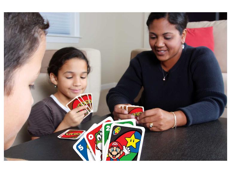 Familie speelt een kaartspel aan tafel, met kaarten met stripfiguren.
