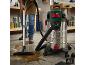 Man ruimt gemorste vloeistof op met een nat- en droogzuiger in een werkplaats.