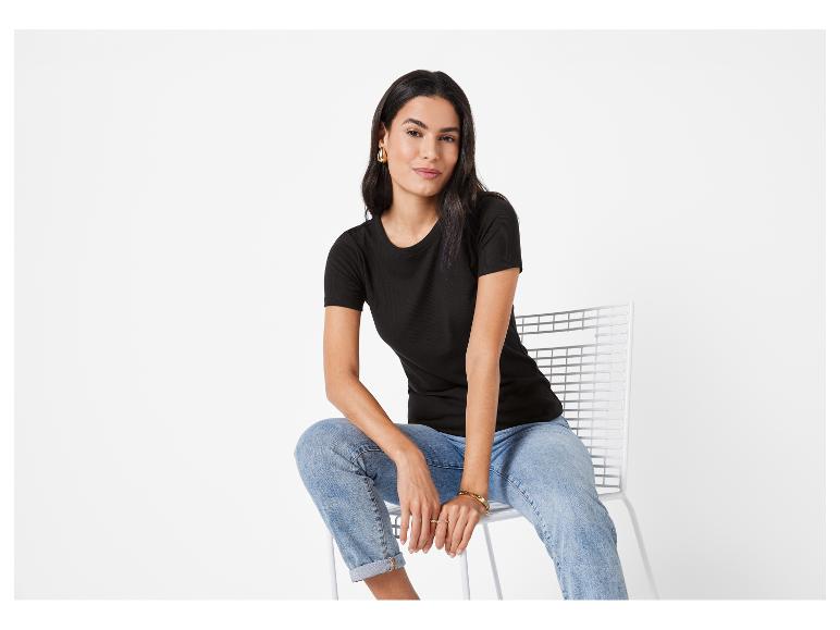 Model in zwart t-shirt en jeans.