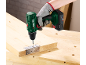 Gehandschoende hand gebruikt een accuboormachine om een scharnier op een houten plank te schroeven.