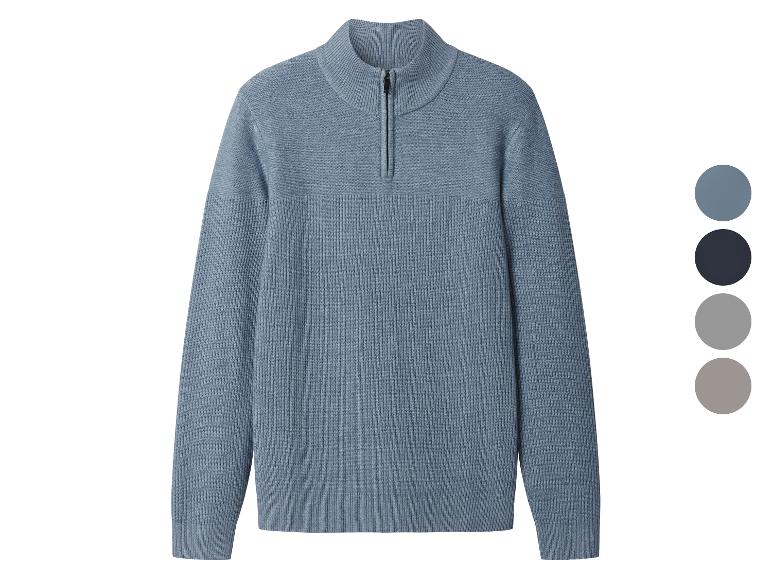 Blauwe gebreide trui met korte rits en kleurenpalet.