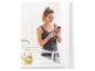 Vrouw in sportkleding gebruikt smartphone in de keuken met fruit en water.