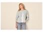 Vrouw in lichtblauwe gebreide cardigan en jeans