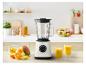 Blender met fruit en twee glazen sap op een houten aanrecht in de keuken.