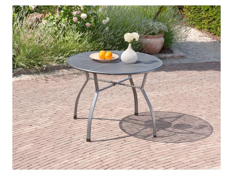 Ronde tuintafel met fruit en vaas op een terras.