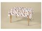 Wit tafelkleed met herfstbladpatroon op een houten tafel.